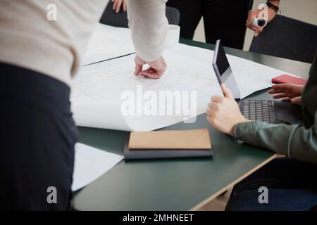 People looking at plans during meeting Stock Photo