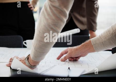 Hands pointing on blueprint, close-up Stock Photo