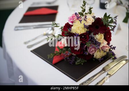 Wedding bouquet of flowers on reception table ready for evening meal and party Stock Photo