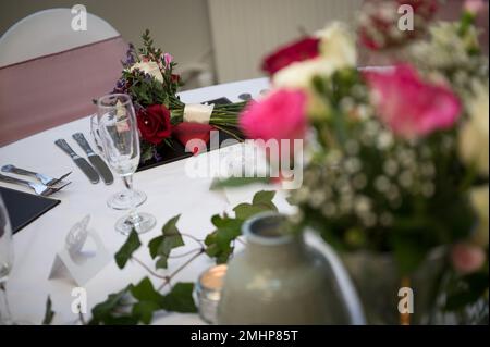 Wedding bouquet of flowers on reception table ready for evening meal and party Stock Photo