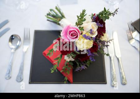 Wedding bouquet of flowers on reception table ready for evening meal and party Stock Photo