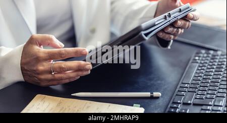 Businesswoman hand are working on the tablet at office. Uses modern technologies to make report or answer email to customer  at office room for multit Stock Photo