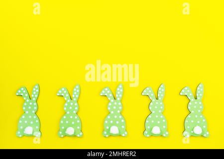 Easter background made of colored bunny, rabbits, hares from the backcn a yellow background. Minimal festive spring concept. Stock Photo