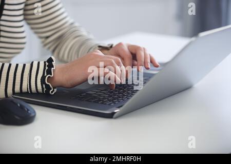 Female programmer coding on laptop computer. Young woman typing text on modern notebook pc keyboard Stock Photo