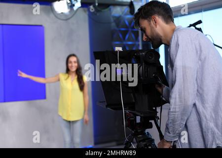 Professional video camera operator and presenter working in studio Stock Photo