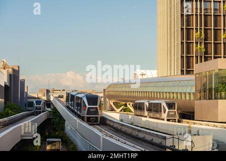 Changi Airport, Singapore - January 24, 2020: Changi Airport sky trains traveling between terminals at sunset time viewed from one of the gates Stock Photo