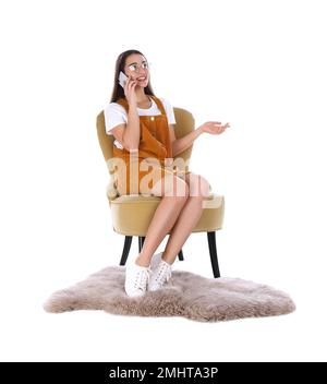 Young woman talking by phone in armchair isolated on white Stock Photo