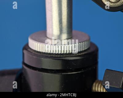Closeup microphone mounting screw on a blue background. Stock Photo