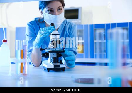 Scientist working with microscope indoors. Laboratory analysis Stock Photo