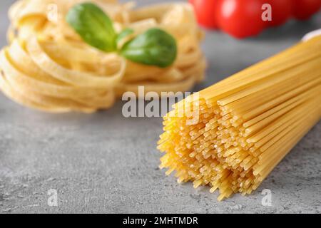 Uncooked spaghetti on grey table against blurred lights. Italian pasta ...