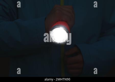 Man with bright flashlight in evening, closeup Stock Photo