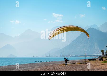 Man practicing paragliding on a windy day on the beach by the sea Stock Photo