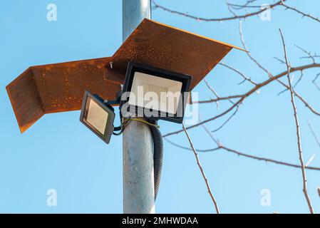 Solar powered led spotlight mounted on the outer wall of the warehouse Stock Photo