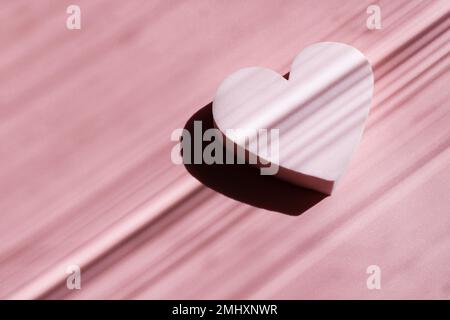 Pink powdery cosmetic sponge in the form of a star on a pink background with deep shadows. Beauty concept. Stock Photo