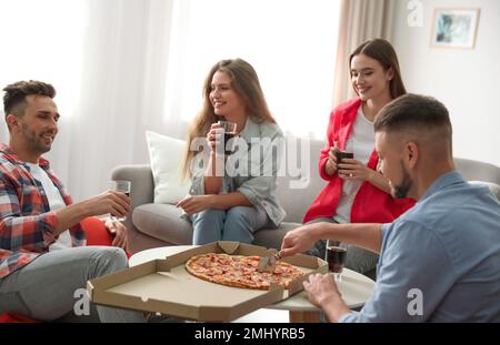Group of friends with drinks and pizza at home Stock Photo