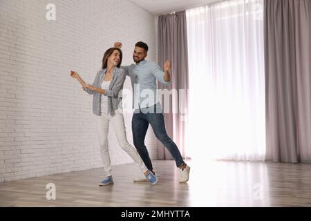 Lovely young couple dancing together at home Stock Photo