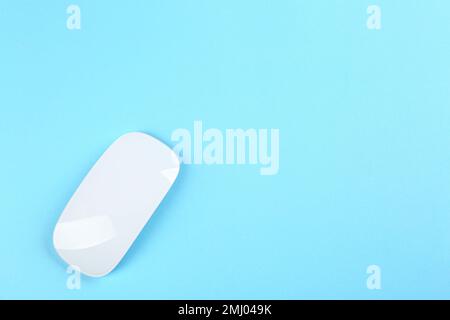 Modern wireless optical mouse on light blue background, top view. Space for text Stock Photo