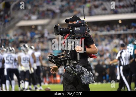 A television cameraman works on the field during the second half