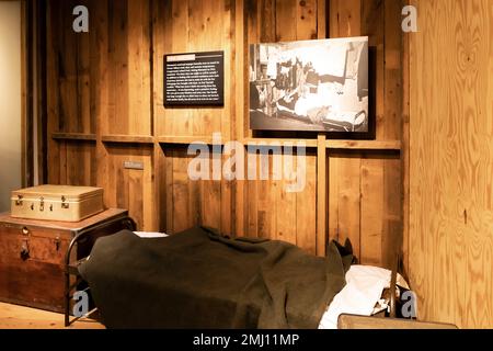 Cot and suitcases in exhibit about Manzanar life, NPS Visitor Center at Manzanar National Historic Site, Owens Valley, California, USA Stock Photo