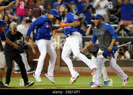 New York Mets shortstop Luis Guillorme (13) and Pete Alonso, right, tear  the jersey off teammat …