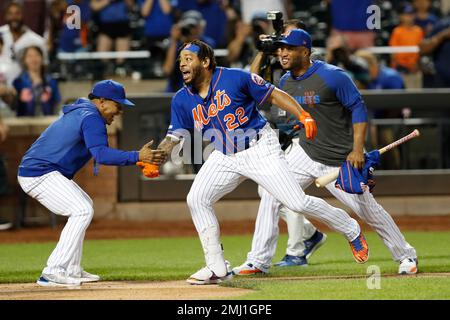 New York Mets shortstop Luis Guillorme (13) and Pete Alonso, right, tear  the jersey off teammat …