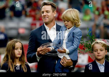 Former Arizona Cardinals quarterback Carson Palmer stands with his family  as team president Michael Bidwill speaks after being added to the Cardinals  ring of honor at half time of an NFL football