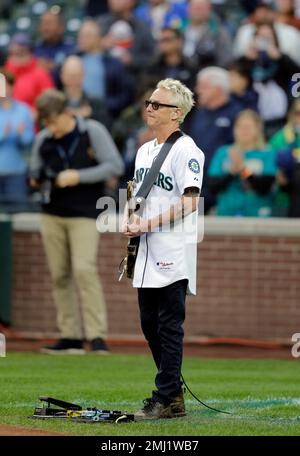 Mike McCready of the band Pearl Jam, poses for photos on the field after  performing the National Anthem before a baseball between the Chicago White  Sox and the Seattle Mariners on Friday