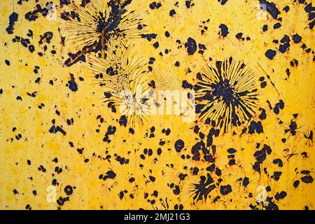 Detail of peeling yellow paint on the rusty surface of a backhoe Stock Photo