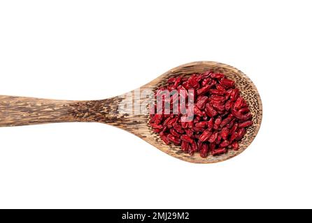 Pile of dried Berberis vulgaris also known as common barberry, European barberry or barberry on wood spoon, isolated on white background. Stock Photo