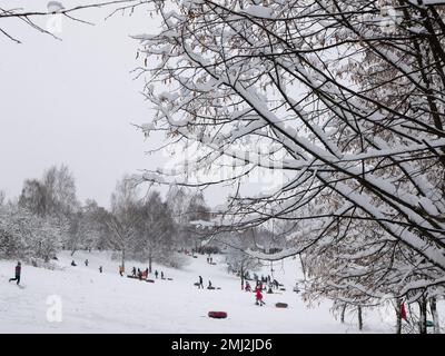 Snow tubing park, selective focus. Children and adults with snow tubes enjoying of sliding on snow Stock Photo