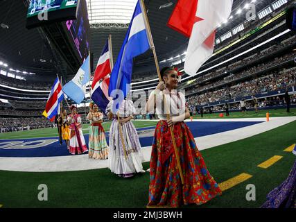 Dancers hold flags of nations of hispanic heritage honoring Hispanic  Heritage Month prior to a NFL