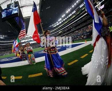 Dancers hold flags of nations of hispanic heritage honoring Hispanic  Heritage Month prior to a NFL football game between the Miami Dolphins and  Dallas Cowboys in Arlington, Texas, Sunday, Sept. 22, 2019. (