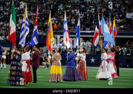 Dancers hold flags of nations of hispanic heritage honoring Hispanic  Heritage Month prior to a NFL football game between the Miami Dolphins and  Dallas Cowboys in Arlington, Texas, Sunday, Sept. 22, 2019. (