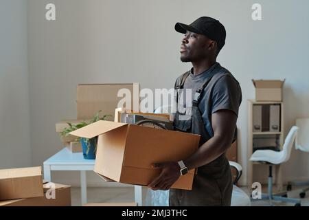 African American worker carrying cardboard boxes with things to a new office Stock Photo