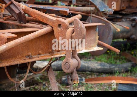 Photograph of old and rusty heavy duty metal hook attached to a large D-Bolt at the end of an unused and scrapped rail carriage Stock Photo