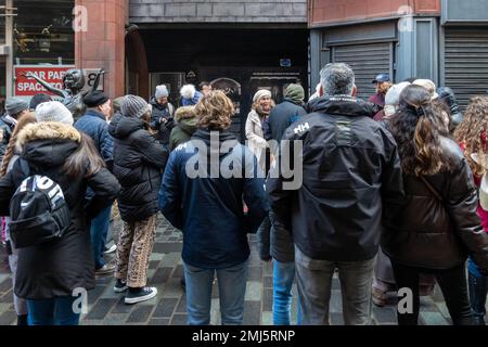 Outside the original entrance to the Cavern Club on Mathew Street in Liverpool. Tourists and tour guide Stock Photo