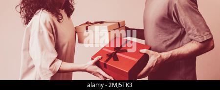 Valentine's Day concept, couple in love giving each other gifts in present boxes. Stock Photo