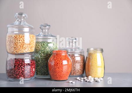 Jars with different cereal grains on marble table Stock Photo - Alamy