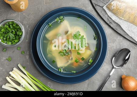 Flat lay composition with delicious fish soup on grey table Stock Photo