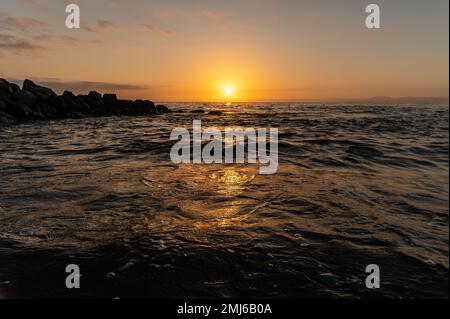The Sun Is Rising As Reflections Sparkle On The Surface Of The Water Stock Photo