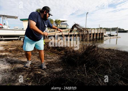 Walker Townsend clears marsh grass from the Isle of Palms marina boat  landing after Hurricane Dorian passed by the Isle of Palms, S.C., Friday,  September 6, 2019, in Charleston, S.C. (AP Photo/Mic