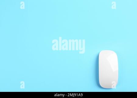 Modern wireless optical mouse on light blue background, top view. Space for text Stock Photo