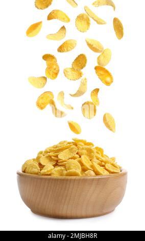 Tasty crispy corn flakes falling into bowl on white background Stock Photo