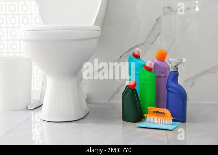 Cleaning supplies and toilet bowl in bathroom. Space for text Stock Photo