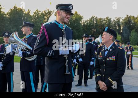 U.S. Army Warrant Officer Cena Duran, commander of the 1st Infantry Division Band, speaks with a clarinet player from the Royal Belgian Air Force as they wait for the start of the parade leading up to the inaugural military tattoo at Vilnius, Lithuania, Aug. 27, 2022. The Big Red One Band is among other units assigned to the 1st Infantry Division, proudly performing alongside NATO allies during a historical, inaugural military tattoo hosted by Lithuanian Armed Forces. AtlanticResolve,EUCOM,FightAsOne,StrongerTogether,USArmy,VictoryCorps, Stock Photo