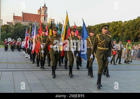 A Lithuanian Armed Forces Honor Guard carrying the flags of NATO Allies marches during a parade leading up to a military tattoo at Vilnius, Lithuania, Aug. 27, 2022. Lithuania invited allied nations to a military tattoo for the first time in its history, including the 1st Infantry Division Band, who proudly performs alongside NATO allies during a historical, inaugural military tattoo hosted by Lithuanian Armed Forces. Stock Photo