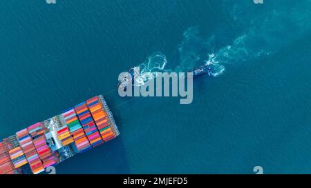 Tub Boat with Stern of cargo ship carrying container and running for import goods from cargo yard port to custom ocean concept technology transportati Stock Photo