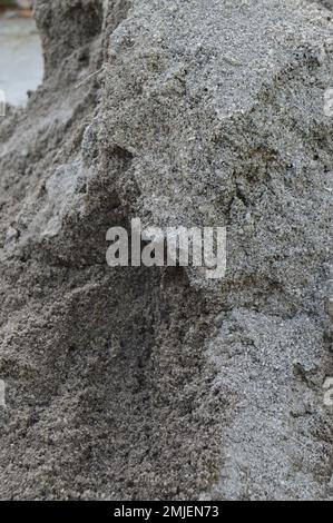 portrait of gray sand dunes as a raw material for building (walls, walls, houses, and so on). Stock Photo