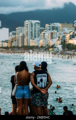 Young man wearing an Ipanema shirt with Ipanema Beach and skyline in background, Rio de Janeiro, Brazil - when life imitates art Stock Photo