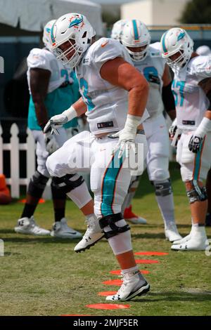 Miami Dolphins guard Michael Deiter (63) carries a football as he warms up  on the field before an NFL football game against the Buffalo Bills, Sunday,  Sept. 19, 2021, in Miami Gardens